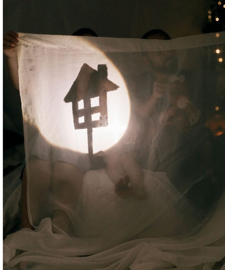 Flashlight beam illuminating a paper house shape taped to a wall during a indoor scavenger hunt activity