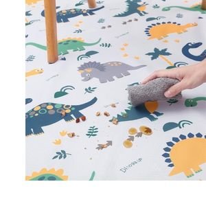 Waterproof non-slip splash mat with colorful animal print placed on the floor for toddler sensory bin play.