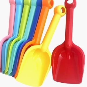 Four colorful plastic toy shovels and scoops in blue, yellow, red, and green for toddler sensory bin play.