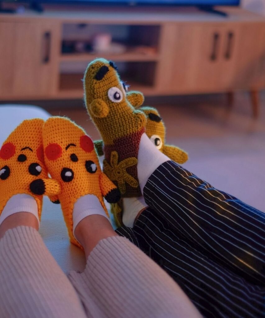Parent and toddler playing with colorful patterned sock puppets on their feet during an indoor activity