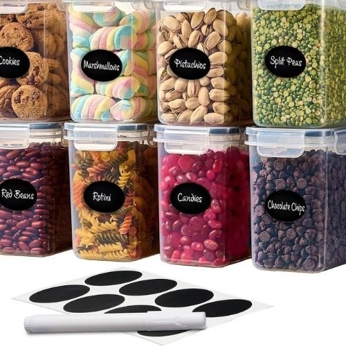 Stack of clear airtight plastic storage containers with black locking lids filled with dry pantry ingredients